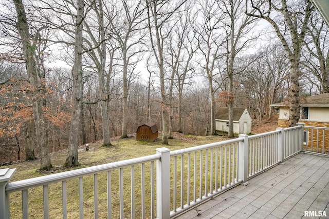 wooden terrace with a lawn and a storage unit