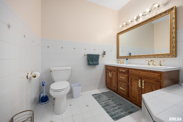 bathroom with tile patterned flooring, vanity, tile walls, and toilet