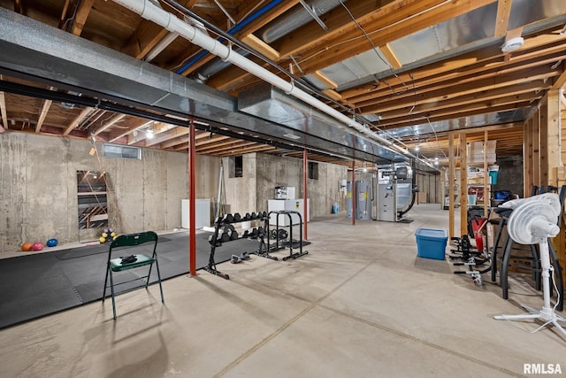 basement featuring washer / dryer, electric water heater, and heating unit