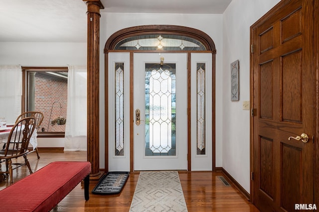 foyer entrance featuring ornate columns and hardwood / wood-style flooring