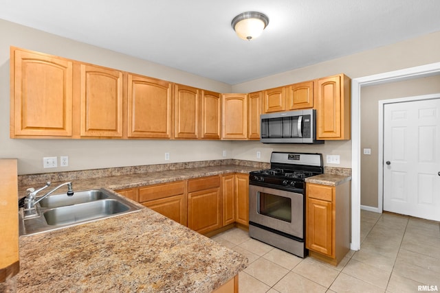 kitchen with sink, light tile patterned flooring, and appliances with stainless steel finishes