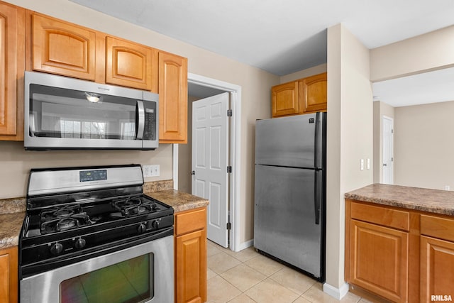 kitchen featuring light tile patterned flooring and appliances with stainless steel finishes