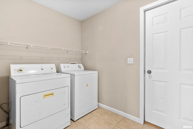 laundry room with washing machine and dryer and light tile patterned floors