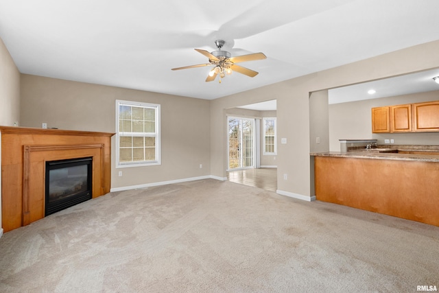 unfurnished living room featuring ceiling fan and light colored carpet