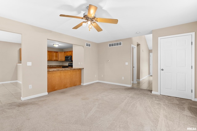 unfurnished living room with light carpet and ceiling fan