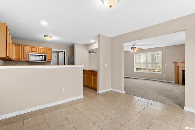 kitchen featuring ceiling fan, light tile patterned flooring, and appliances with stainless steel finishes