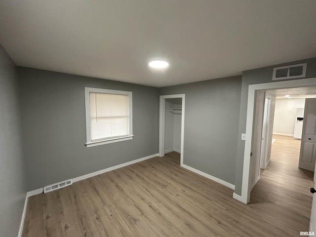 unfurnished bedroom featuring a closet and light hardwood / wood-style flooring