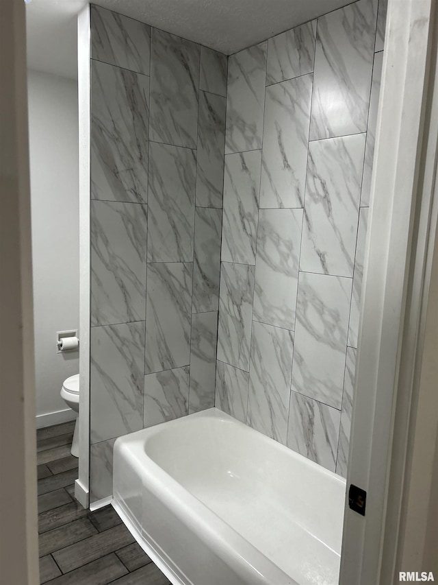 bathroom featuring bathing tub / shower combination and toilet