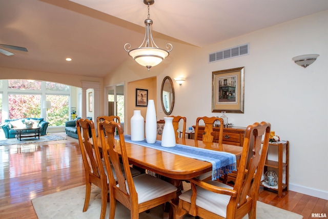 dining area featuring ornate columns, ceiling fan, vaulted ceiling, and hardwood / wood-style flooring