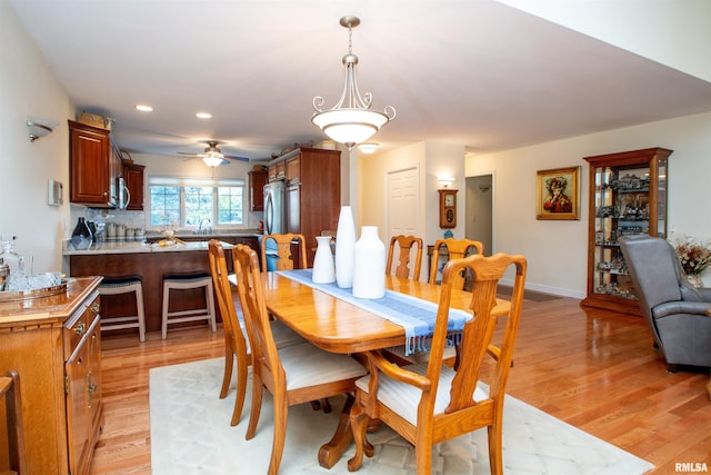 dining area with ceiling fan and light hardwood / wood-style floors