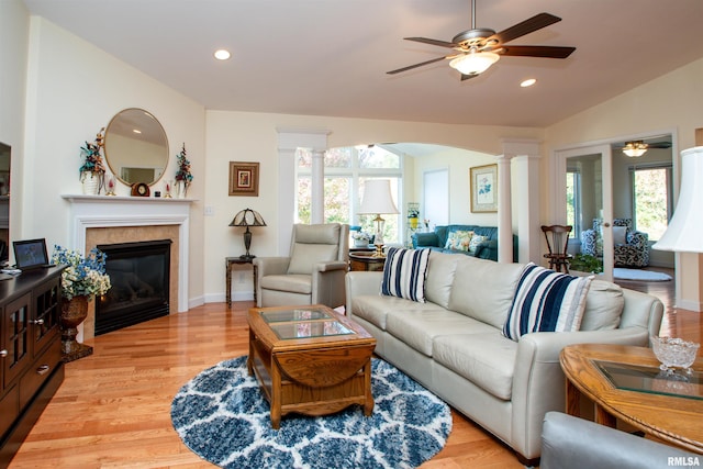 living room with vaulted ceiling, light hardwood / wood-style flooring, ornate columns, and plenty of natural light