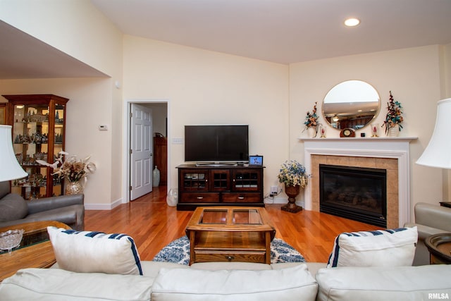 living room featuring hardwood / wood-style floors and a tiled fireplace