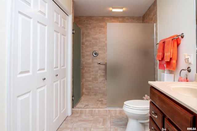 bathroom with tile patterned floors, vanity, toilet, and an enclosed shower