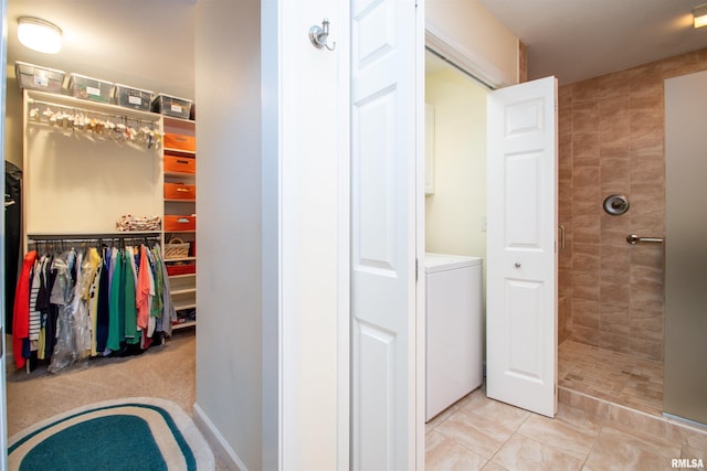 bathroom featuring washer / clothes dryer and tiled shower