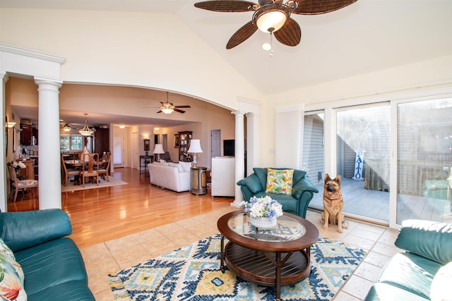 living room featuring light tile patterned floors, decorative columns, high vaulted ceiling, and ceiling fan