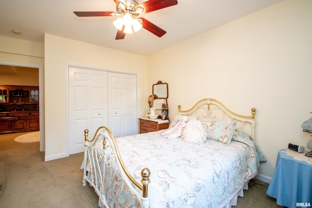 carpeted bedroom with ceiling fan and a closet