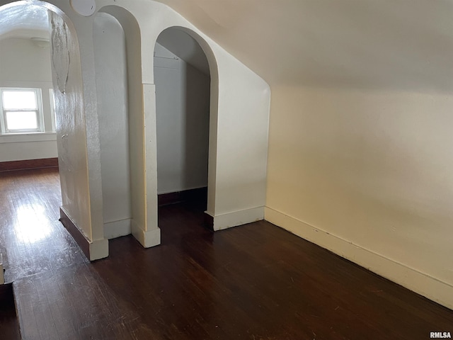 additional living space featuring dark hardwood / wood-style flooring and vaulted ceiling