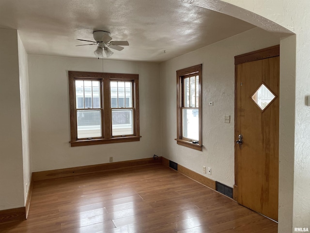 entrance foyer featuring ceiling fan, wood-type flooring, and a healthy amount of sunlight