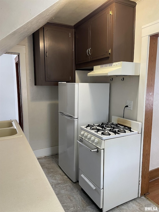 kitchen featuring white gas range, sink, and dark brown cabinets