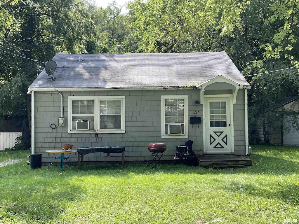 bungalow-style home with a front yard