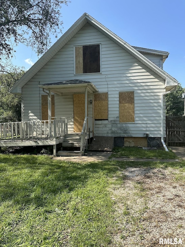 rear view of house featuring a porch and a yard