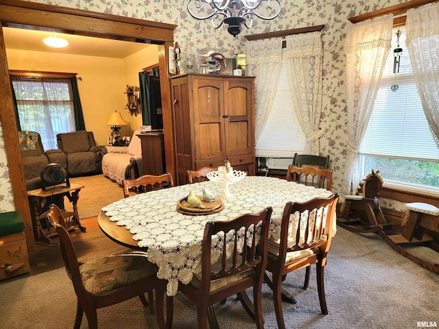 dining space featuring light colored carpet and a chandelier