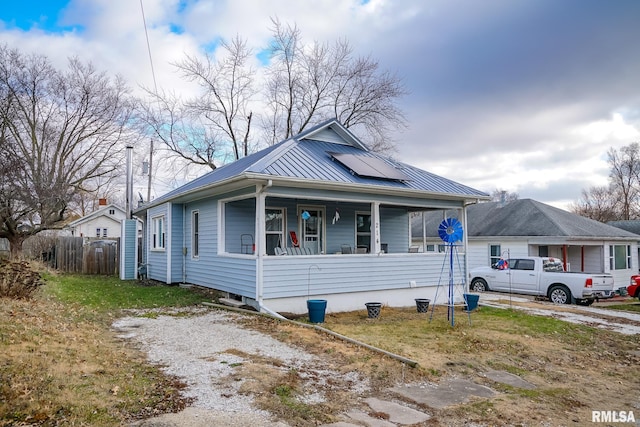 bungalow featuring solar panels and covered porch