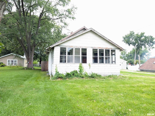 rear view of property featuring a lawn