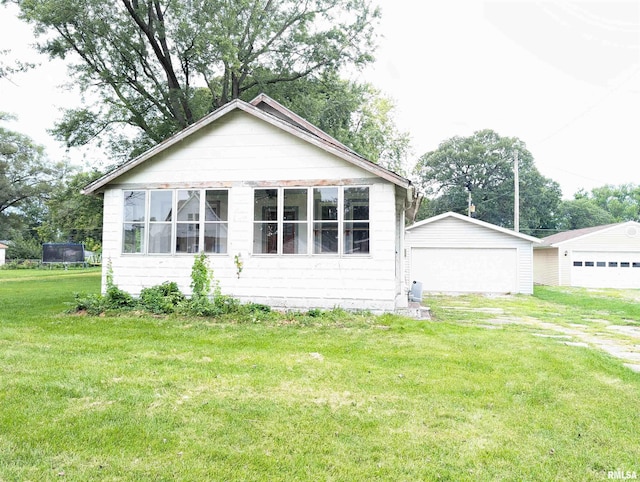 view of front facade featuring a garage, an outdoor structure, and a front lawn