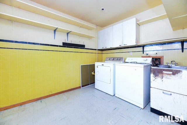 laundry room featuring cabinets and washing machine and dryer