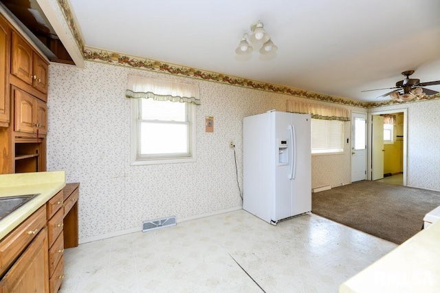 kitchen with white fridge with ice dispenser, a baseboard heating unit, and ceiling fan