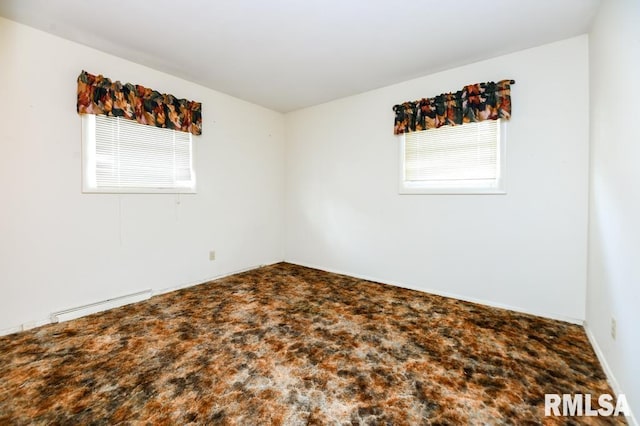 carpeted spare room with a baseboard radiator