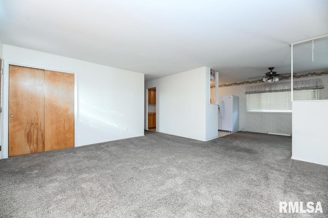 unfurnished bedroom featuring carpet, white fridge, a closet, and ceiling fan