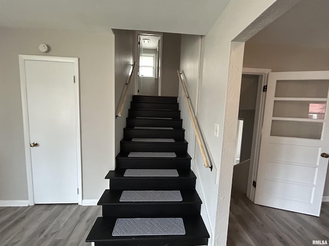 staircase featuring built in features and wood-type flooring