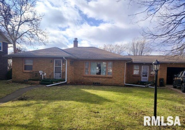 ranch-style home with a front lawn and a garage