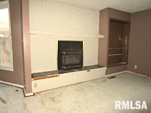 unfurnished living room featuring a wood stove