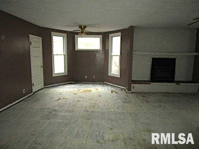 unfurnished living room featuring ceiling fan