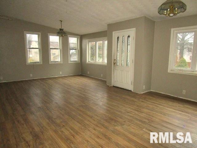 interior space with a textured ceiling, lofted ceiling, hardwood / wood-style flooring, and a notable chandelier