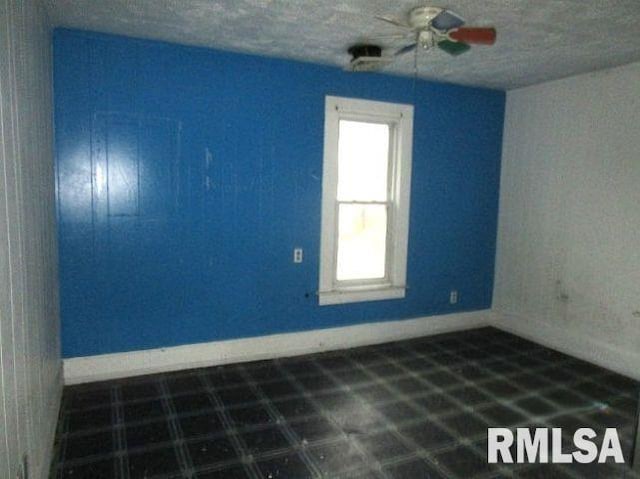 534 S Main St, Canton, IL 61520 - spare room with ceiling fan, baseboards, and a textured ceiling