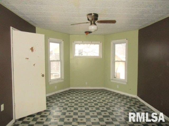 534 S Main St, Canton, IL 61520 - unfurnished room with tile patterned floors, healthy amount of natural light, ceiling fan, and baseboards