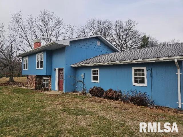 rear view of house featuring a yard