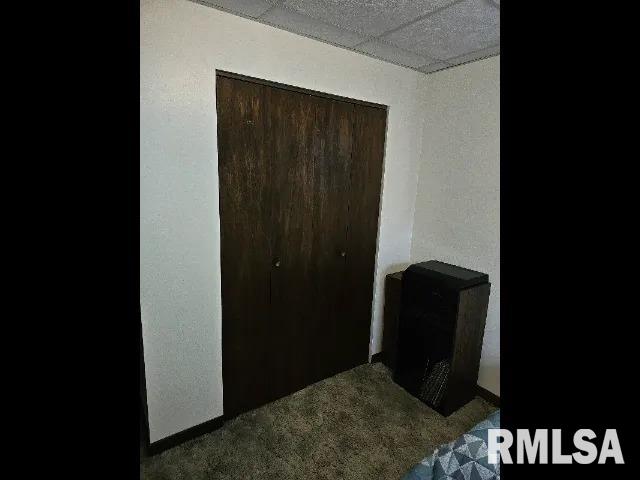 bedroom with a drop ceiling and carpet