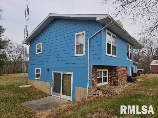 rear view of property with a lawn