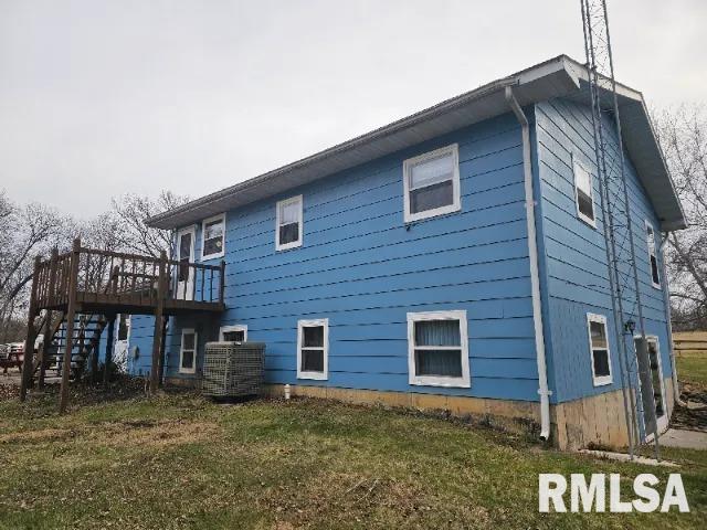 rear view of property featuring a yard, a deck, and cooling unit