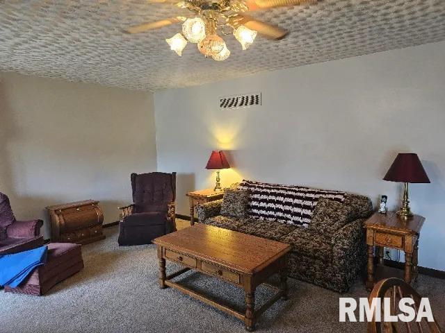 carpeted living room with ceiling fan