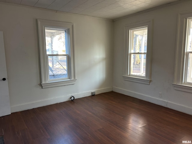 spare room featuring dark hardwood / wood-style flooring and ornamental molding