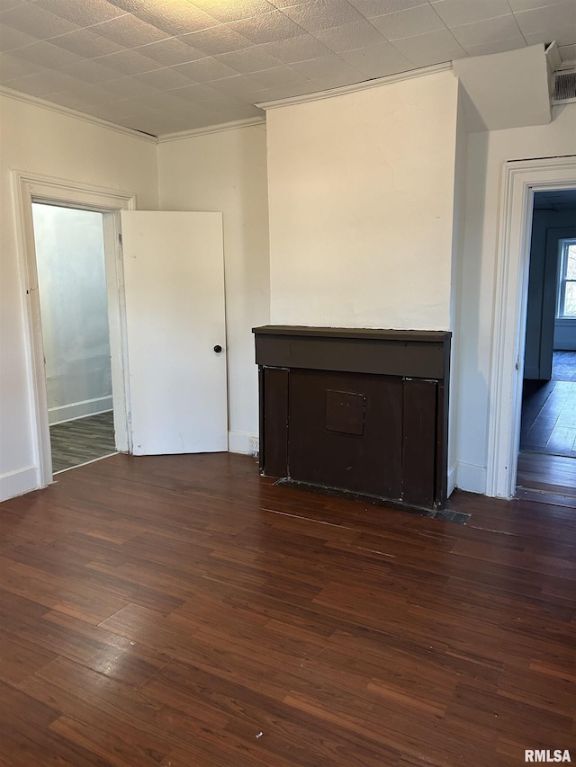 empty room with crown molding and dark wood-type flooring