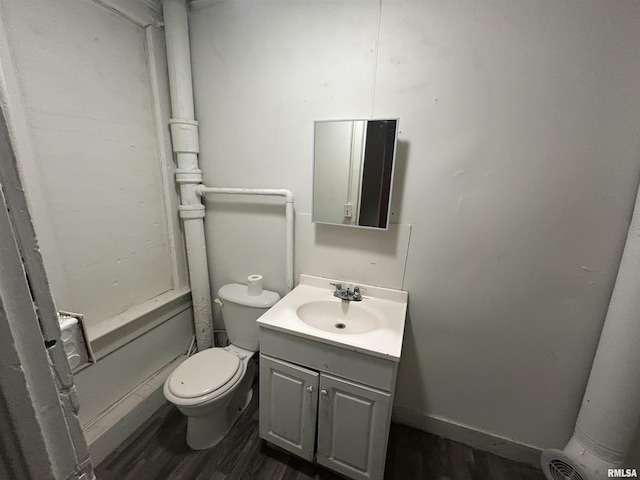 bathroom featuring toilet, vanity, and hardwood / wood-style flooring