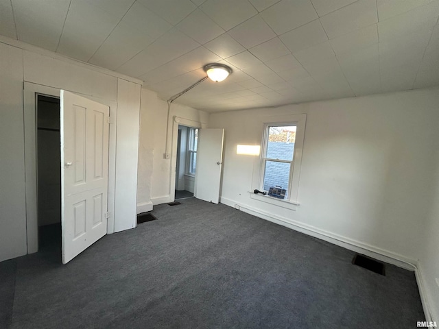 unfurnished bedroom with dark carpet