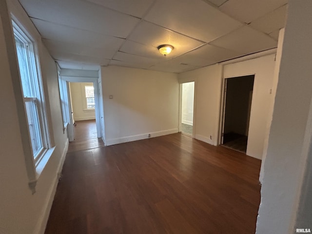 spare room featuring a drop ceiling and dark hardwood / wood-style floors